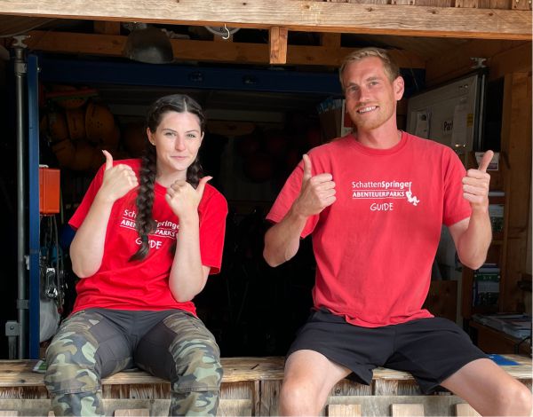 Zwei Mitarbeiter recken l�chelnd die Daumen in die H�he