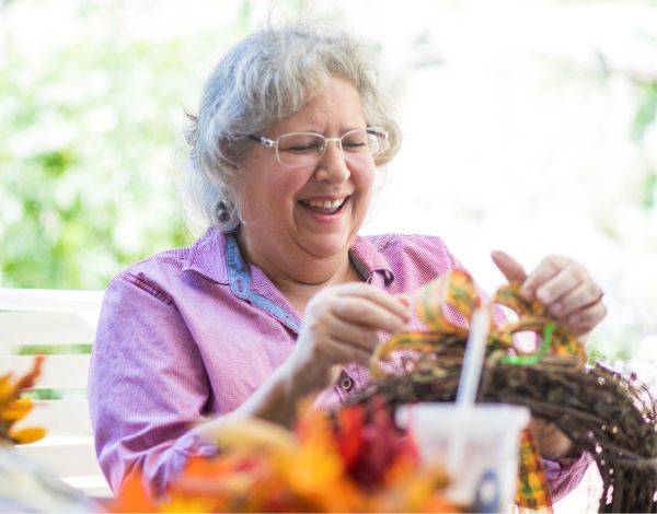 Eine �ltere Dame dekoriert einen Kranz